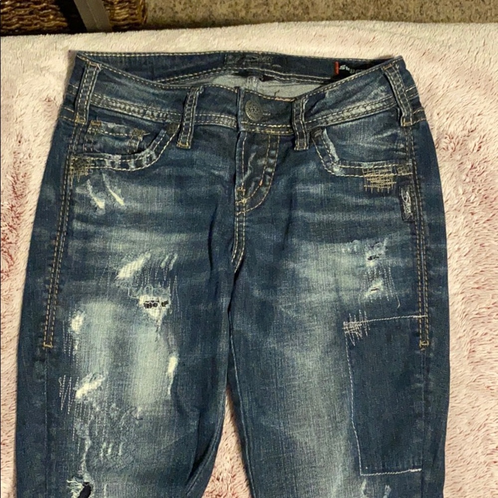 Silver jeans, tight.